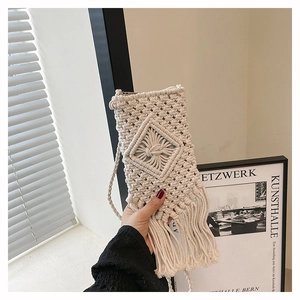 Detail of macramé woven pattern and long tassels on a cream handmade mini crossbody bag