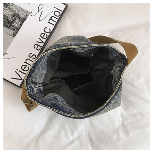 Detailed interior of blue denim tote bag showing zipper pocket and spacious compartments