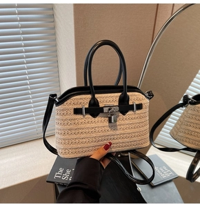Detailed close-up of woven straw handbag with black leather trim and silver square lock