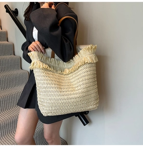 Detail of woven tote bag featuring decorative ruffle edges and leather shoulder straps