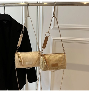 Détail de sacs bandoulière tissés avec chaînes dorées et perles décoratives au mur
