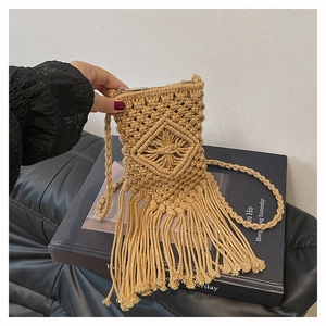 Detailed close-up of handmade macrame khaki crochet bag with fringes and woven strap