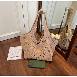 Detail of hand-woven beige tote bag with yellow wavy pattern and openwork crochet texture