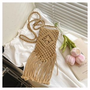 Detail of hand-woven cotton phone bag with diamond patterns and long fringe tassels