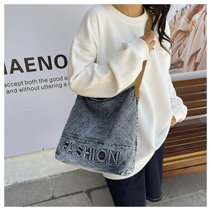 Close-up of snowflake blue denim tote bag featuring fashion letter print and brown strap