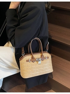 Handwoven straw handbag with brown leather trim and silver clasp shown by a model