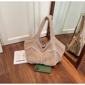 Detail of hand-woven tote bag featuring khaki knit texture and white wavy trim accents