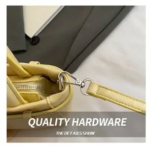 Detail view of premium silver metal lobster clasp and textured leather on yellow bag