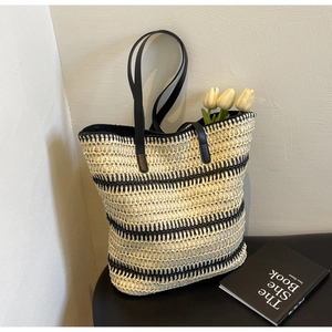 Gros plan sur un cabas en paille rayé avec anses noires et décor de tulipes