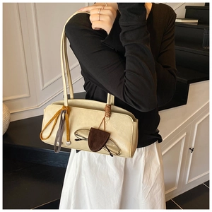 Détail du sac crème avec étui à lunettes marron et pendentif en forme de coeur décoratif