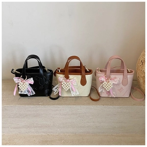 Detailed view of mini butterfly tote bags in black, beige, and pink with heart charms