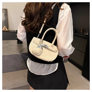 Detail of cream croc-effect handbag with silver twist lock and heart-shaped coin purse