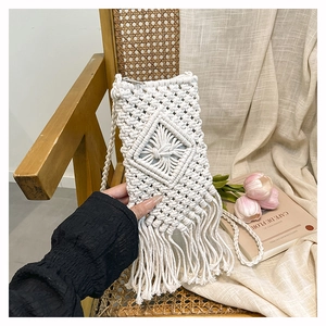 Detail of bohemian woven crossbody bag with tassel fringe and diamond patterns