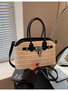 Fashionable beige woven straw handbag with black leather straps and metal buckle lock
