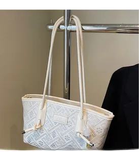 Detail einer eleganten beigen Tragetasche mit geometrischer Jacquard-Stickerei und Leder