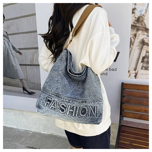 Close-up of snowflake blue denim tote bag with fashion lettering and brown strap