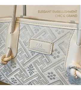 Detailansicht des Jacquard-Stoffs mit Blumenstickerei auf einer weißen Umhängetasche