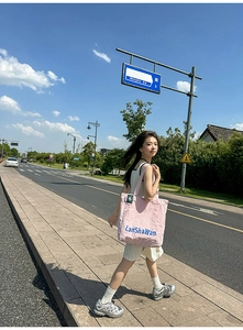 Détail du sac cabas en nylon rose avec texte bleu LanShaWan et étiquette logo verte