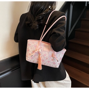 Detailansicht der pinkfarbenen Schultertasche mit geometrischem Muster und Quaste