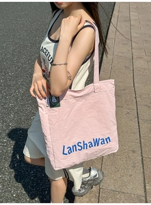 Détail du grand sac cabas en toile rose montrant l'écusson chat et l'intérieur en nylon