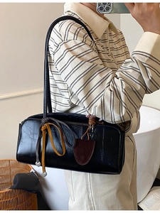 Sac baguette minimaliste en cuir noir avec texture litchi et pendentif coeur à l'épaule