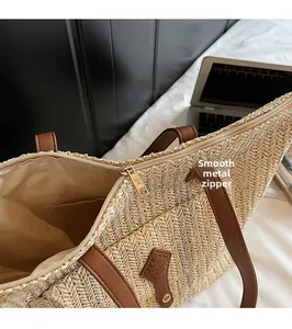 Detail of woven straw tote bag showing interior zipper and smooth golden metal puller
