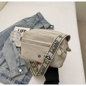 Vue détaillée du sac bandoulière en nylon avec poches zippées et bandoulière à trèfle