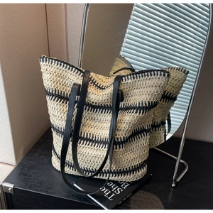 Détail macro du sac cabas tissé à rayures avec bandoulières en cuir noir et doublure