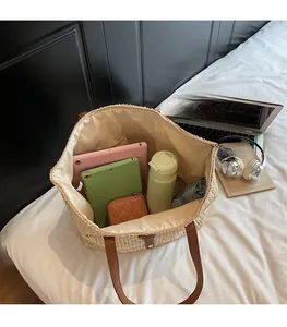 Top view of spacious straw tote bag interior holding a water bottle and electronics