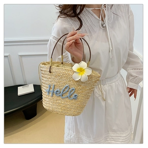 Detail der Strohhandtasche mit Hello-Stickerei, Frangipani-Blüte und rundem Griff