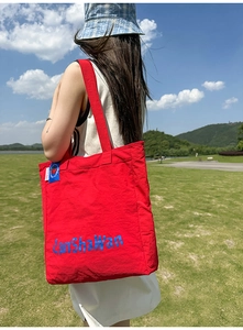 Vue détaillée du grand sac cabas en nylon rouge vif avec imprimé LanShaWan bleu et bandoulière