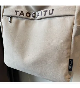 Dettaglio borsa tote in tela beige con chiusura a zip e superficie in tessuto a trama