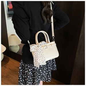 Detail of cream square crossbody bag with polka dot scarf and elegant metal buckle