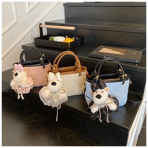Sacs seaux tressés chic avec pendentifs chiots en peluche et perles sur décor en bois noir