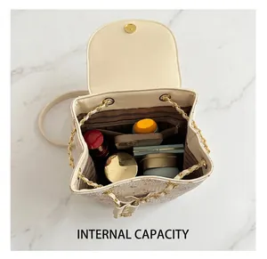 Interior view of mini beige leather backpack showing spacious storage and chain straps