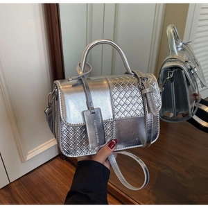 Detail of silver metallic crossbody bag featuring woven texture and fashion tag