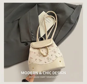 Detail of cream leather backpack with bear prints and decorative gold metal chain