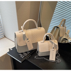 Detail of cream white PU leather handbag set featuring woven flap and silver chain strap