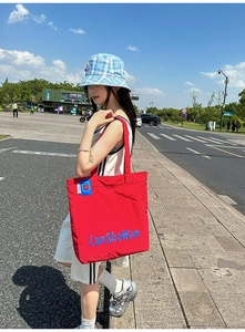 Détail du grand sac cabas rouge en nylon avec imprimé LanShaWan bleu et patch pomme
