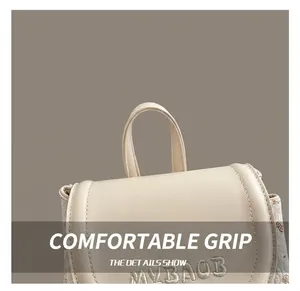 Detail of round leather handle and MYBAOB embroidery on beige minimalist backpack