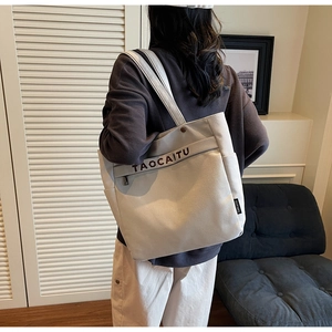 Detail of canvas tote bag with front zipper pocket and TAOCAITU logo branding