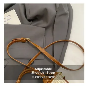 Detail showing the adjustable brown leather strap and woven texture of the bucket bag