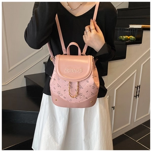 Detailed view of pink mini backpack with golden chain and cute cartoon bear pattern