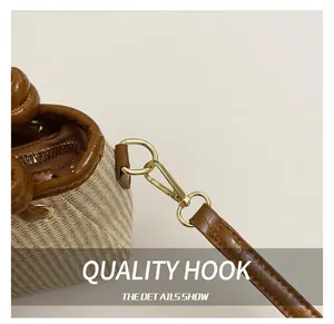 Detailed close-up of golden metal hooks and premium brown leather trim on a woven bag