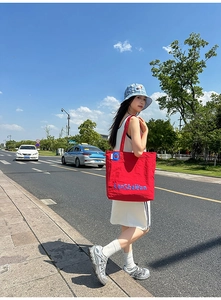 Vue détaillée du sac cabas en nylon rouge avec motif LanShaWan bleu en plein air