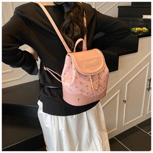 Detailed view of the pink mini backpack featuring floral print and gold chain strap