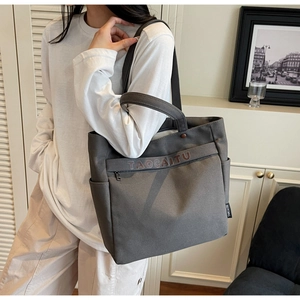 Detail of dark grey canvas tote bag with letter print and sturdy shoulder handle