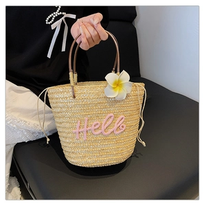 Detailansicht der Stroh-Tragetasche mit Hello-Stickerei, Blüte und runden Griffen