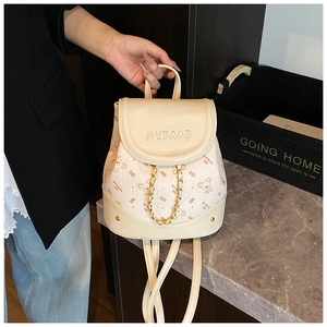 Detail of cream mini backpack featuring teddy bear prints and gold chain decoration