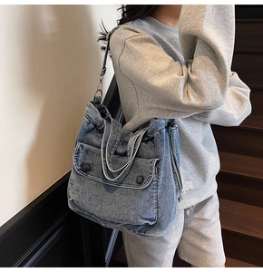 Details der blauen Denim-Tasche mit Kordelzugfalten und silbernen Metallbeschlägen